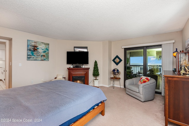 carpeted bedroom featuring a textured ceiling and access to outside