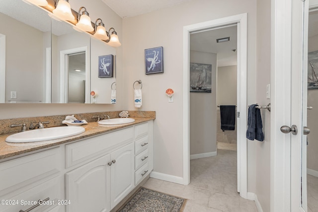 bathroom with double vanity and tile patterned flooring