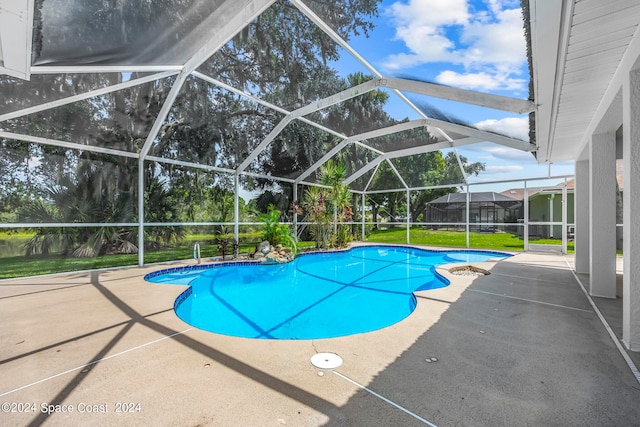 view of swimming pool with glass enclosure, a patio, and a lawn