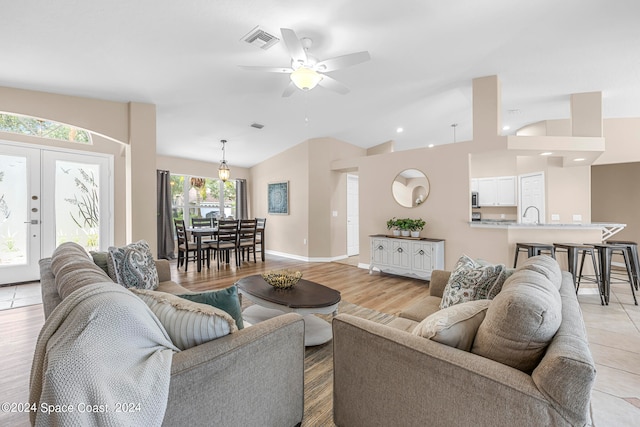 living room with ceiling fan, sink, vaulted ceiling, and light hardwood / wood-style floors