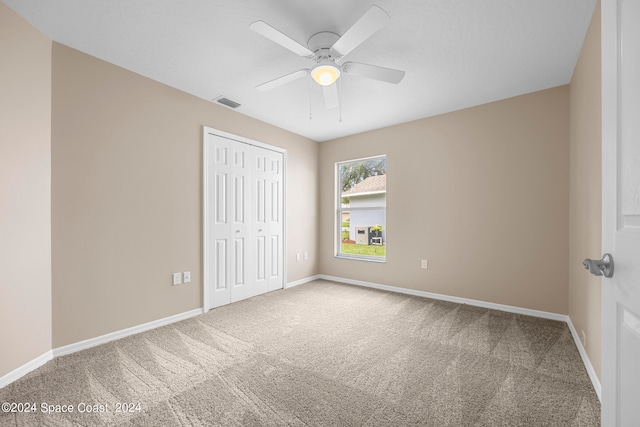 unfurnished bedroom featuring ceiling fan, carpet floors, and a closet