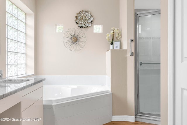 bathroom with vanity, hardwood / wood-style floors, and independent shower and bath