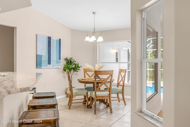 tiled dining space with a chandelier