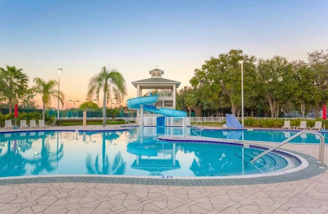 pool at dusk with a water slide