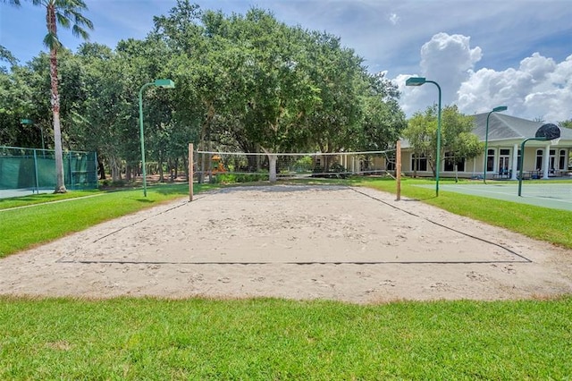 view of community with volleyball court and a lawn