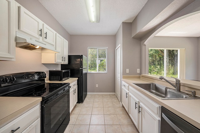 kitchen with a textured ceiling, white cabinets, black appliances, light tile patterned floors, and sink