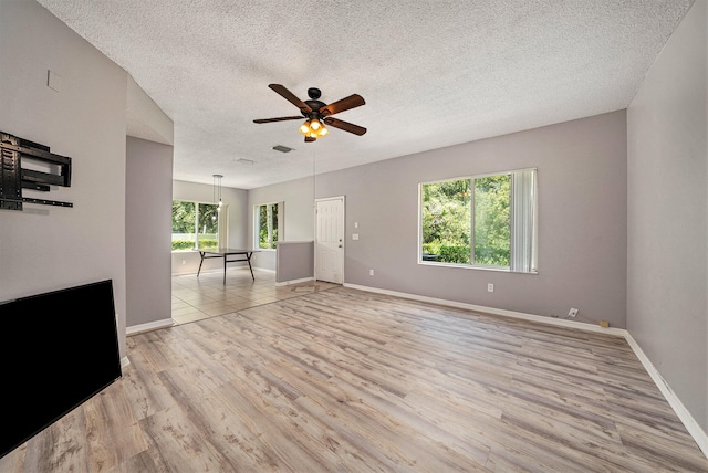 unfurnished room featuring ceiling fan, a textured ceiling, and light hardwood / wood-style floors