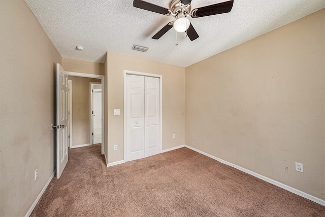 unfurnished bedroom with ceiling fan, a textured ceiling, carpet floors, and a closet