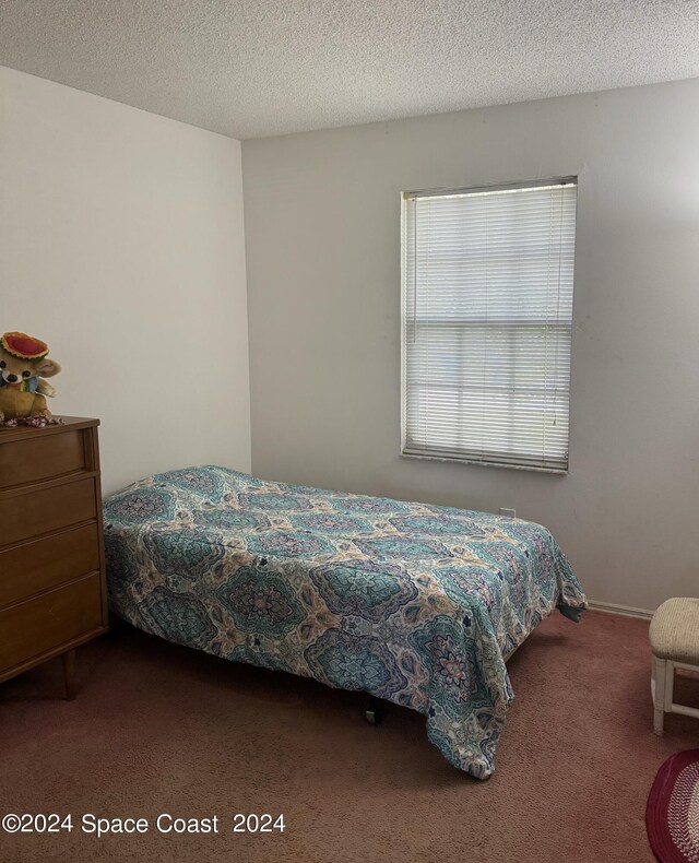 bedroom with carpet floors and a textured ceiling