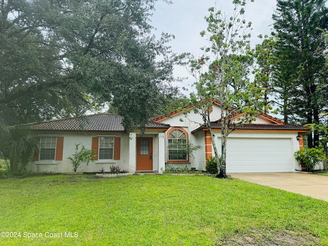 mediterranean / spanish-style house with a garage and a front yard