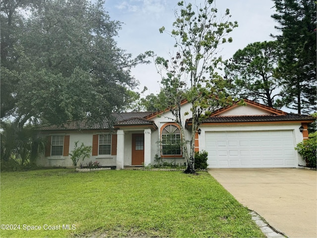 view of front of house featuring a garage and a front lawn