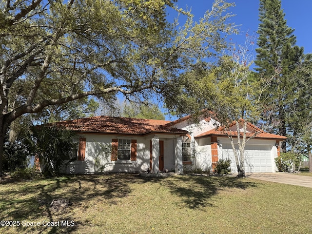 mediterranean / spanish-style home featuring a tile roof, a front yard, driveway, and stucco siding