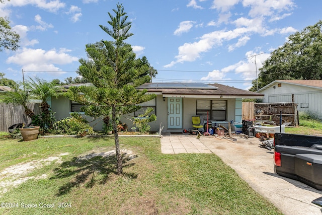 back of house with a yard and solar panels