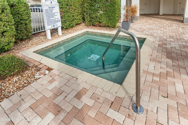 view of pool with a hot tub