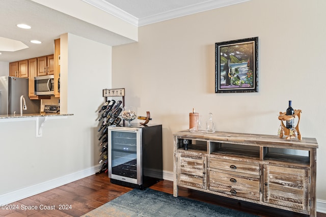 bar featuring stainless steel appliances, wine cooler, ornamental molding, dark hardwood / wood-style flooring, and light brown cabinets