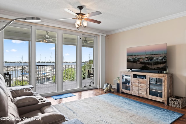 living room with hardwood / wood-style floors, ornamental molding, and a water view