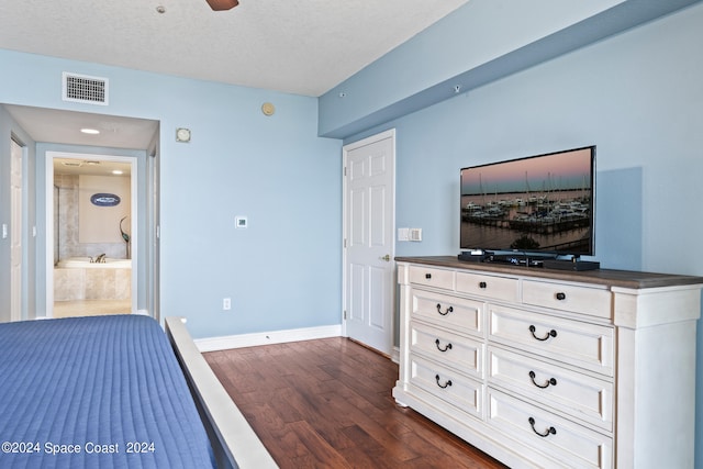 bedroom with dark hardwood / wood-style floors, a textured ceiling, and ensuite bathroom