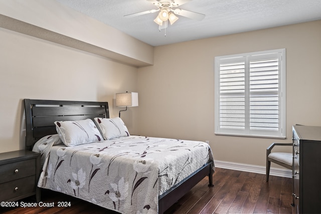 bedroom with multiple windows, dark hardwood / wood-style floors, a textured ceiling, and ceiling fan