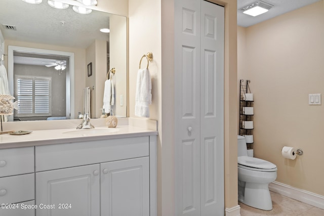 bathroom with ceiling fan, vanity, toilet, and tile patterned flooring