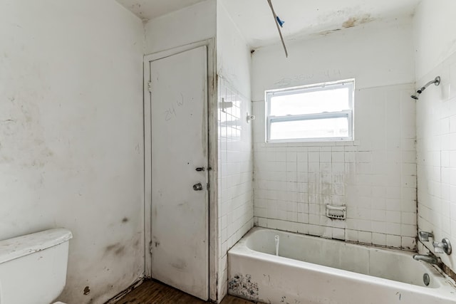 full bathroom with washtub / shower combination, toilet, and wood finished floors