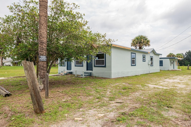 rear view of property with entry steps and a yard