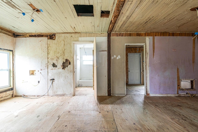 spare room with wood ceiling and a wood stove