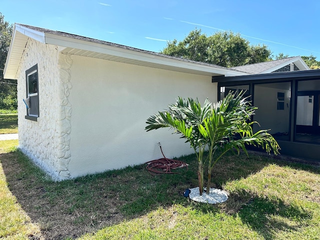 view of side of property featuring a sunroom and a yard