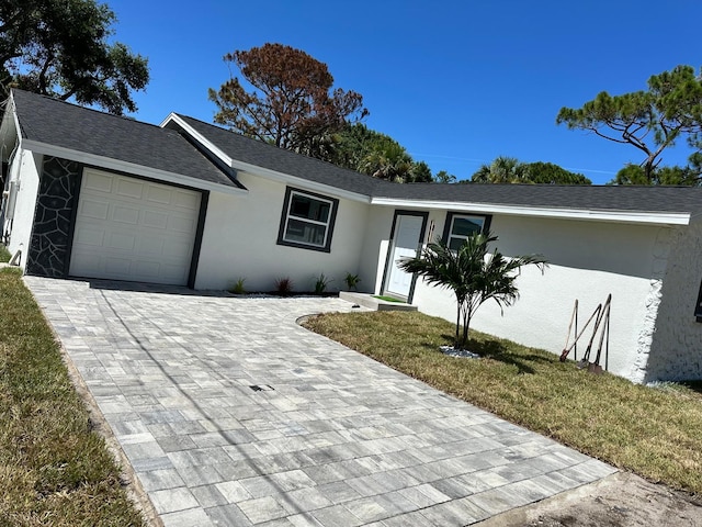 ranch-style house featuring a garage and a front lawn