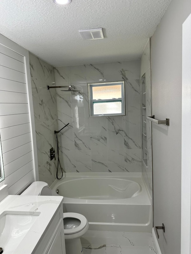 full bathroom featuring tile patterned floors, vanity, tiled shower / bath combo, and toilet