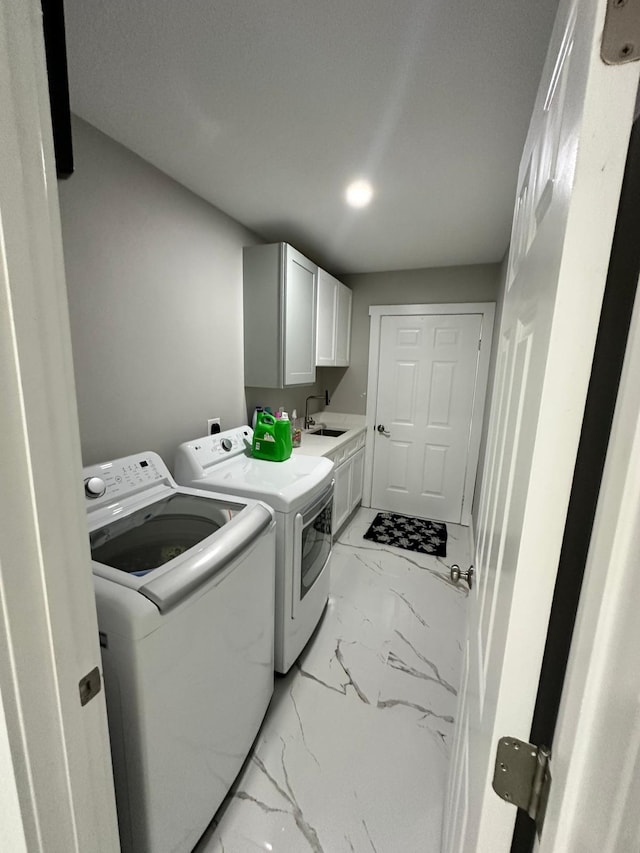 laundry area with washer and clothes dryer, cabinets, and sink