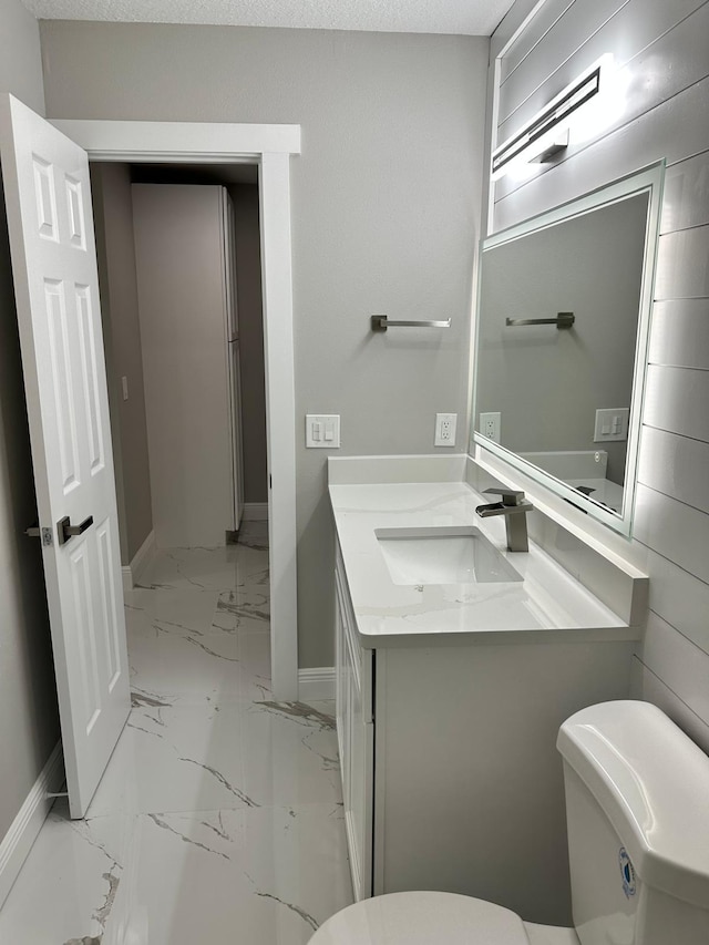 bathroom featuring vanity, a textured ceiling, toilet, and tile patterned flooring