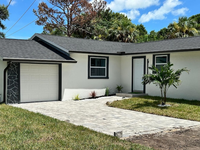 single story home with a front yard and a garage