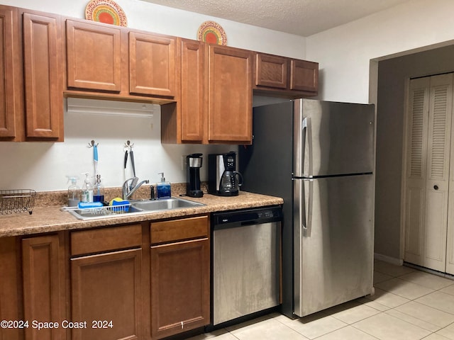 kitchen featuring light tile patterned flooring, appliances with stainless steel finishes, and sink