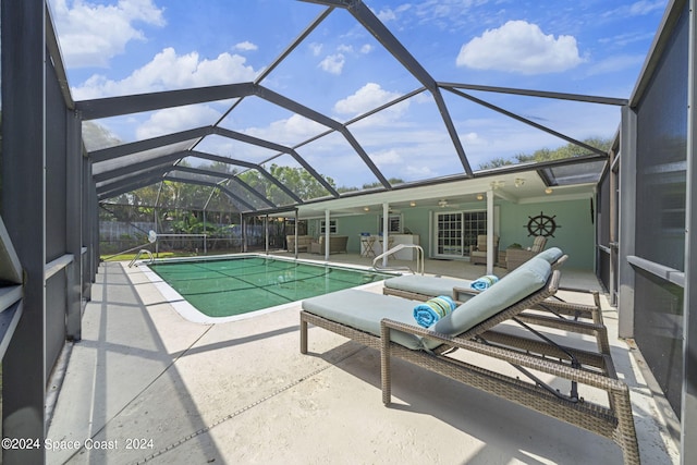 view of swimming pool with glass enclosure and a patio area