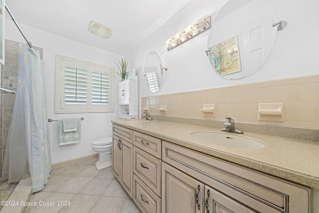 bathroom with decorative backsplash, toilet, double vanity, tile patterned floors, and tile walls