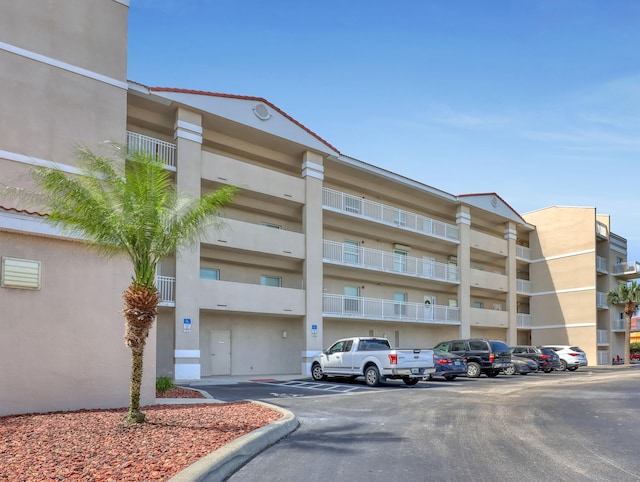 view of building exterior with uncovered parking