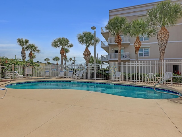 pool featuring fence and a patio