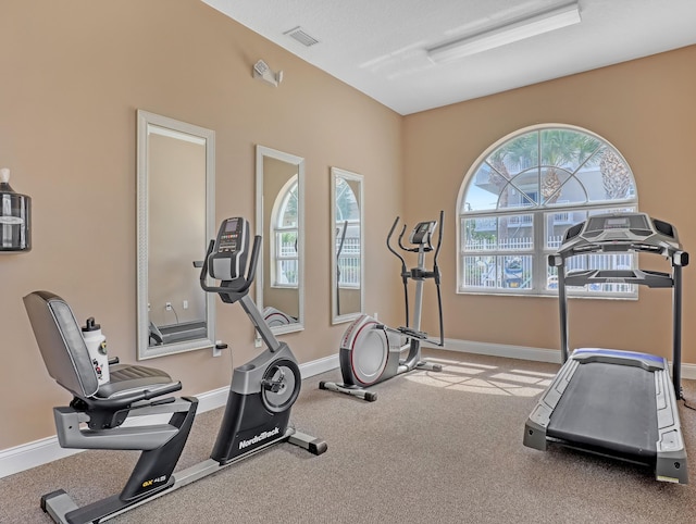 workout area with baseboards, visible vents, and a textured ceiling