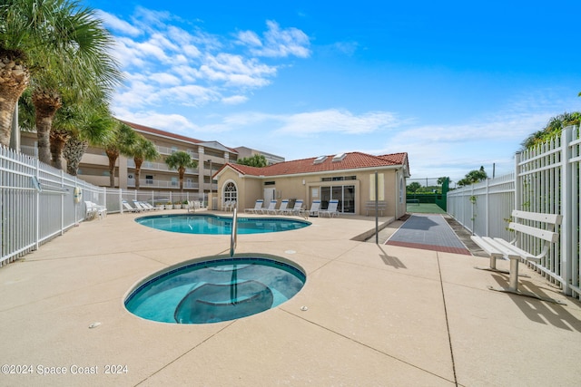 view of pool with a hot tub and a patio area