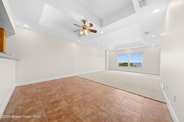 interior space featuring visible vents, a tray ceiling, and baseboards