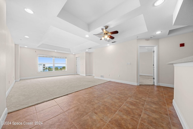 unfurnished living room with recessed lighting, visible vents, baseboards, a tray ceiling, and carpet