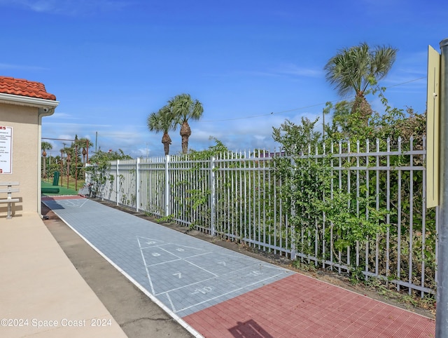 view of home's community with fence and shuffleboard