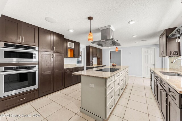 kitchen with sink, a kitchen island, island exhaust hood, black electric cooktop, and double oven