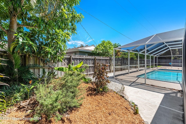 view of pool featuring glass enclosure and a patio area