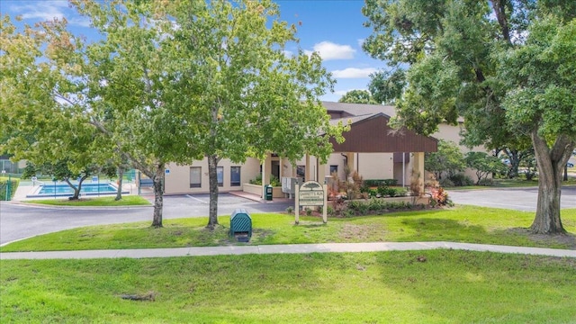 7817 Maplewood Dr Unit 601, Melbourne, FL 32904 - view of front facade with a swimming pool, aphalt driveway, a lawn, and a gazebo