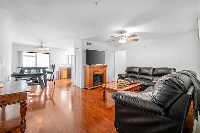 7817 Maplewood Dr Unit 601, Melbourne, FL 32904 - living room featuring a glass covered fireplace, visible vents, ceiling fan, and wood finished floors