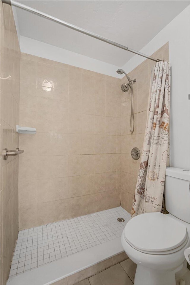 bathroom featuring tile patterned flooring, toilet, and a shower with shower curtain