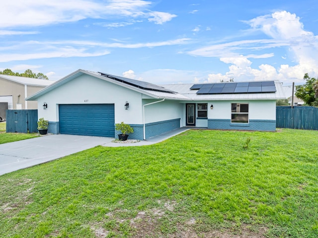 ranch-style home featuring a front lawn, solar panels, and a garage