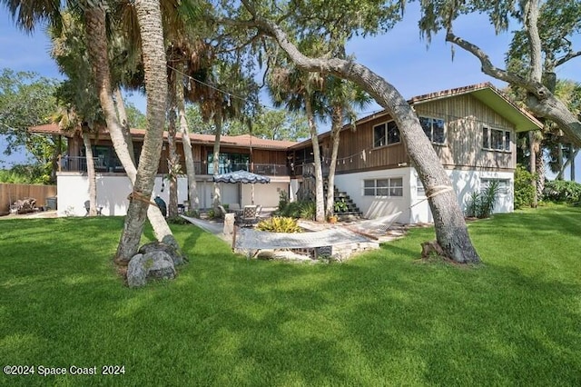 back of house featuring a yard and a garage