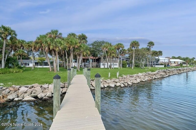 dock area with a water view and a lawn